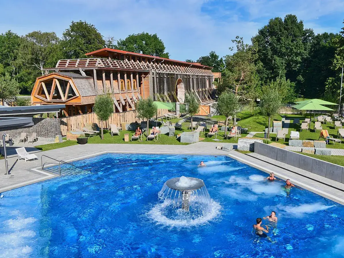 Entspannung pur im Außenpool der besten Therme im Sauerland. Menschen genießen das Wasser, während im Hintergrund die Gradierwerke thronen.