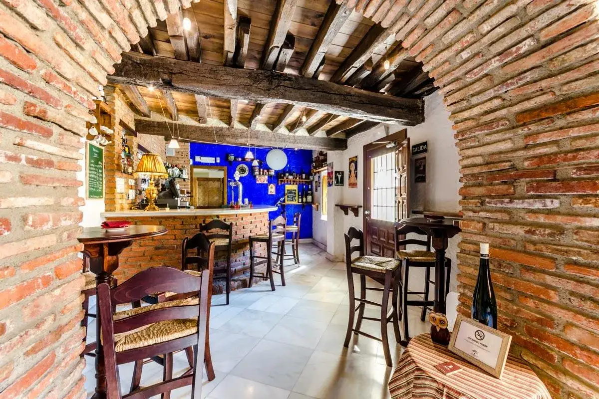 Bar rústico con paredes de ladrillo y vigas de madera. Ideal para saber donde comer en Guadix.