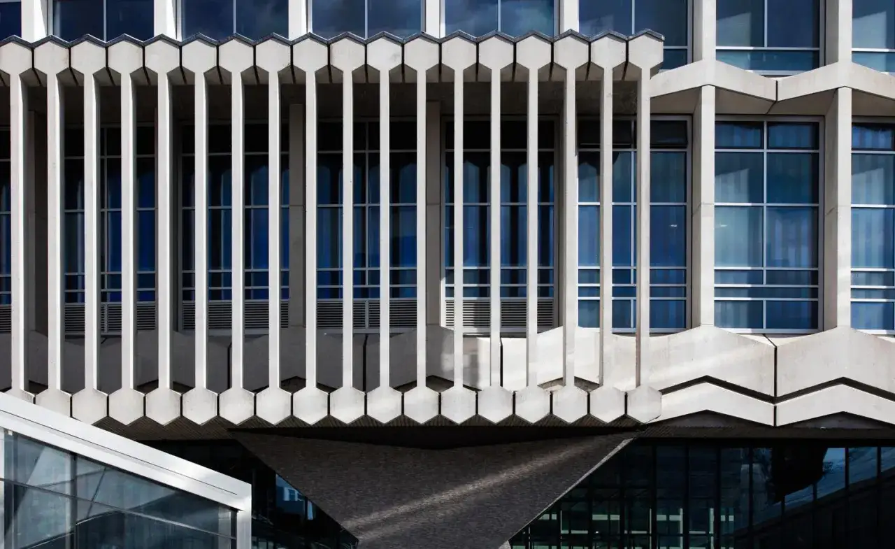 A striking facade of famous brutalist architecture, featuring a rhythmic pattern of concrete fins and blue-tinted windows.