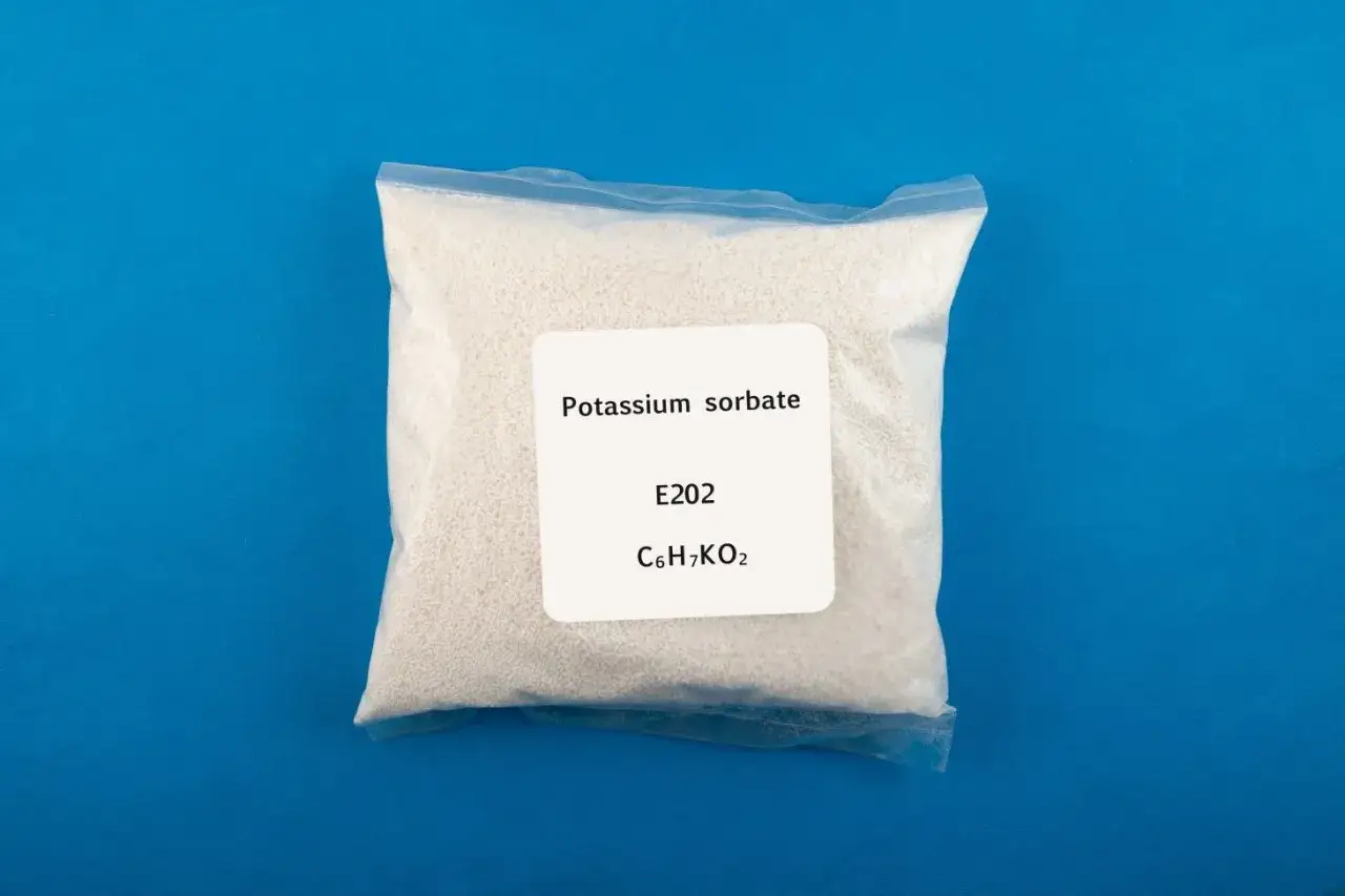 Zgrzewana torebka z białym proszkiem, oznaczona jako Potassium sorbate, E202, C6H7KO2.
