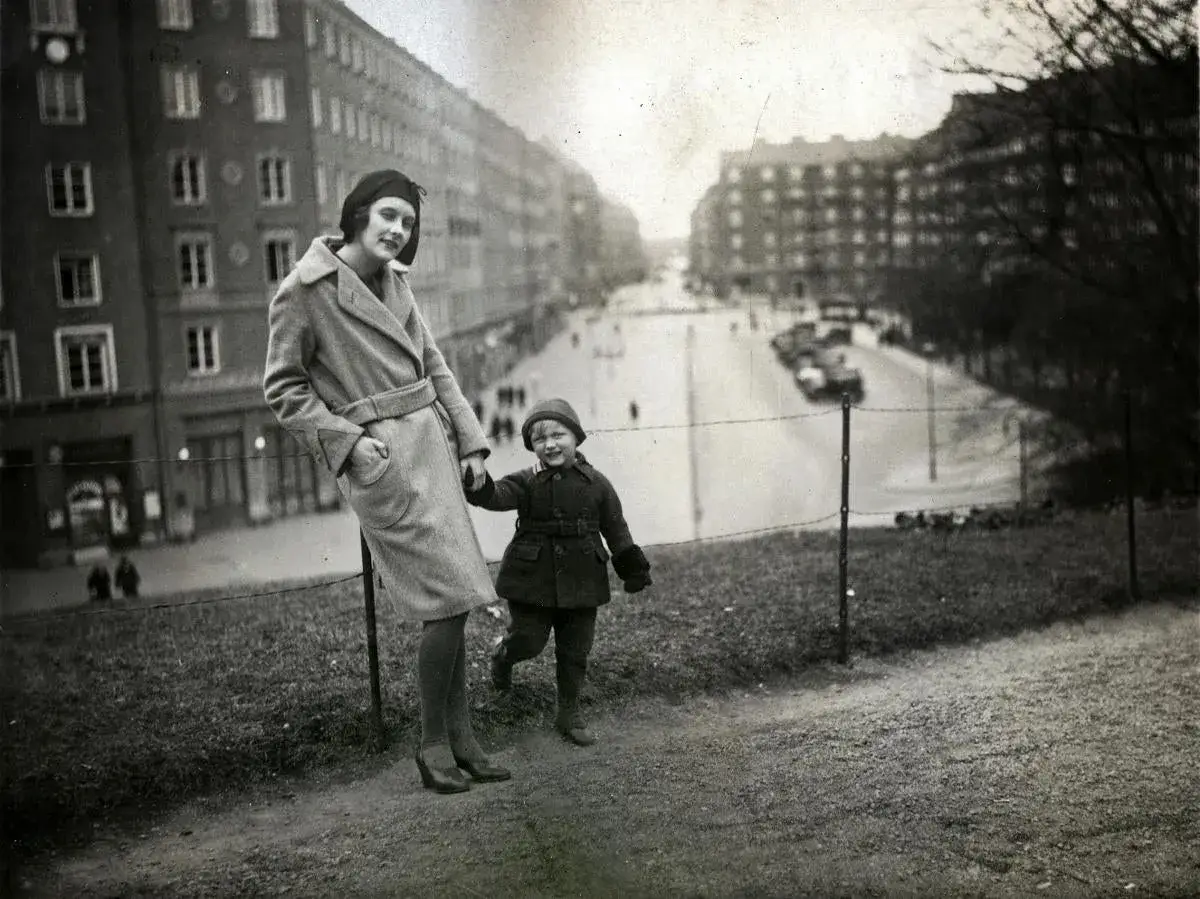 En ung Astrid Lindgren med sitt barn på en promenad i staden. En tidig bild som anspelar på framtida sagor.