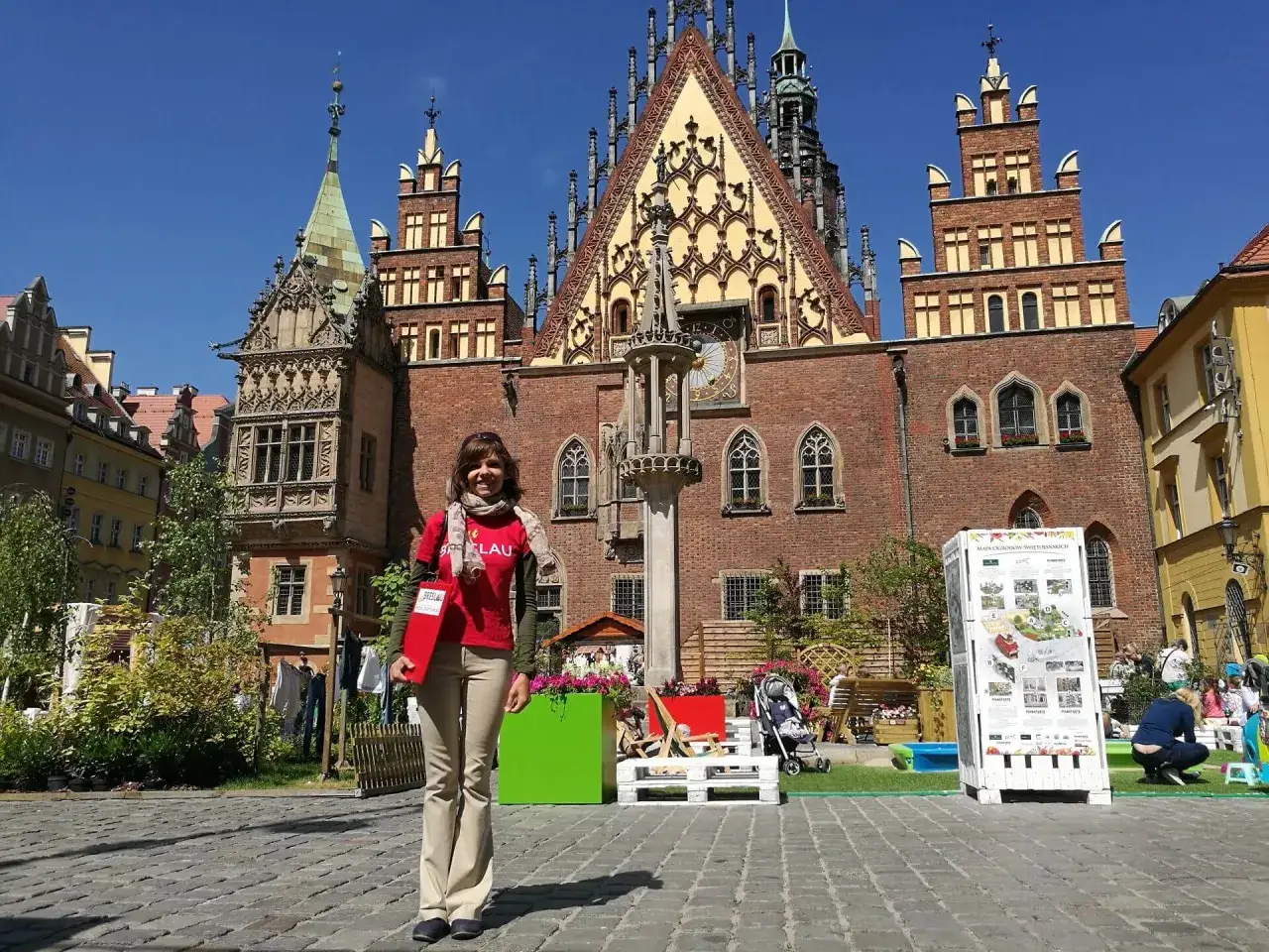 Frau auf einer Stadtrundfahrt in Breslau vor dem historischen Rathaus.