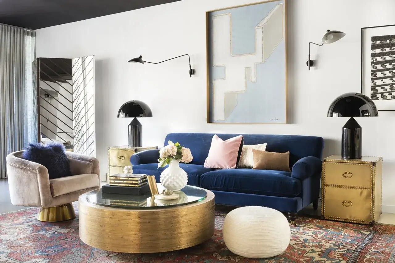 Ein luxuri&ouml;ses Wohnzimmer mit einem tiefblauen Samtsofa, einem goldenen Couchtisch und Akzenten, die zeigen, welche Farbe passt zu Gold.
