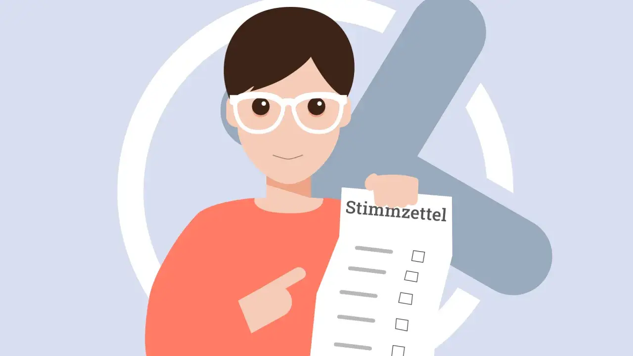 Ein lächelnder Mensch mit Brille hält einen Stimmzettel hoch. Die Wahl ist wichtig, auch bei der Kommunalwahl in Hessen.