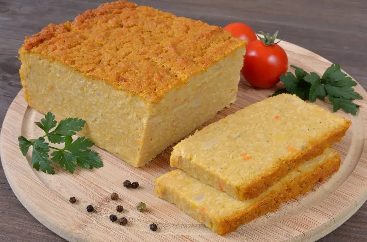 Pyszny pasztet z selera, pokrojony na kromki, z pomidorkami i natką pietruszki na desce.