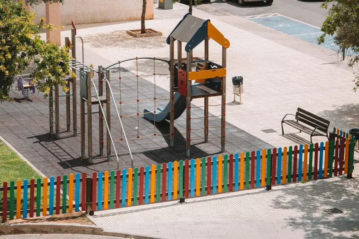Kolorowy plac zabaw z domkiem, zjeżdżalnią i drabinkami. Idealne miejsce, by dowiedzieć się, jak zbudować plac zabaw dla dzieci.