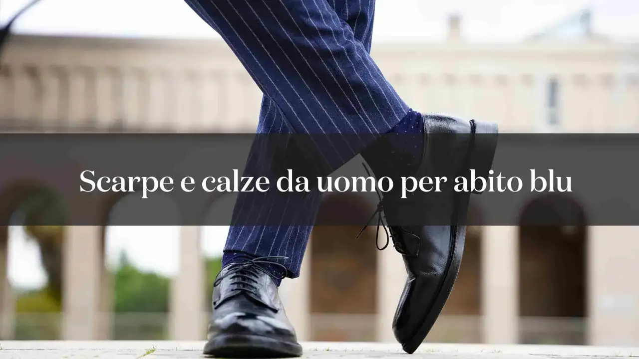 Scarpe nere lucide e calze a pois blu abbinate a un abito blu gessato da uomo.