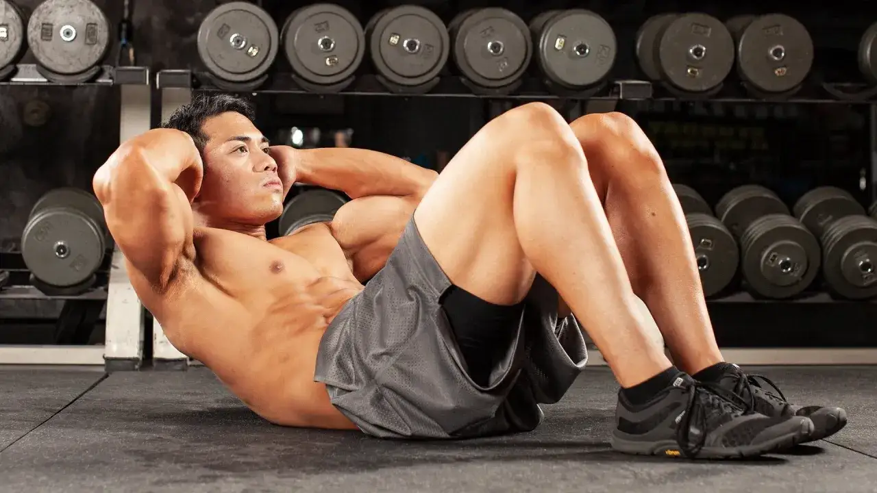 Ein Mann macht Crunches im Fitnessstudio. Die Frage, wie oft bauchmuskeln trainieren, ist wichtig f&uuml;r seine Form.
