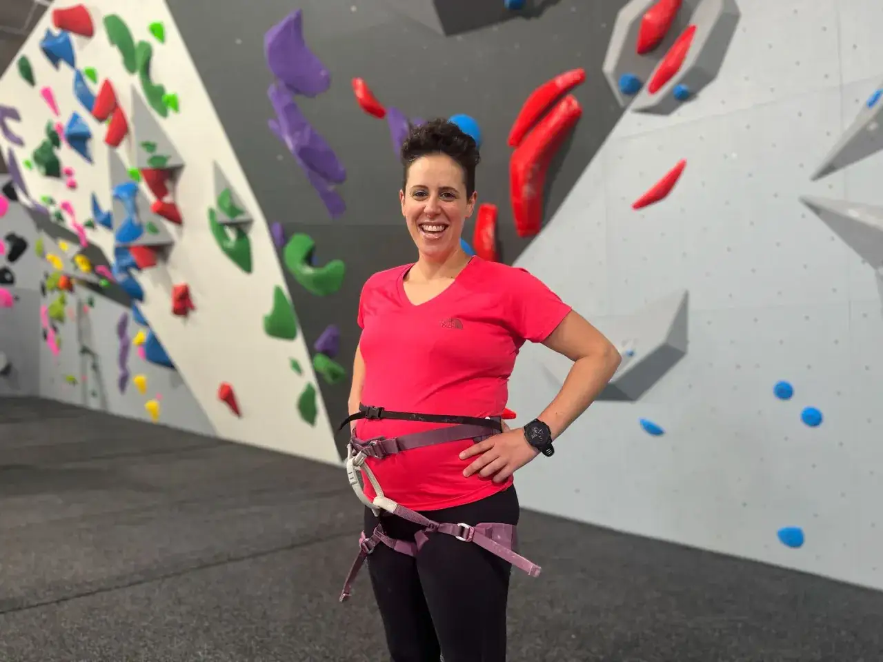 Gl&uuml;ckliche Schwangere beim Bouldern, bereit f&uuml;r neue Herausforderungen an der Kletterwand.