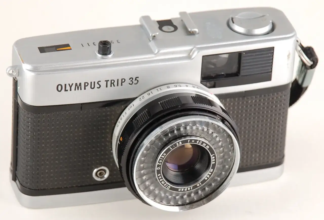 Cámara Olympus Trip 35 plateada y negra, lista para tu próxima aventura fotográfica.