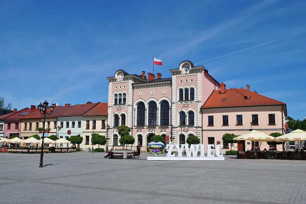 Słoneczny żywiec rynek z ratuszem i kawiarnianymi ogródkami. Białe litery