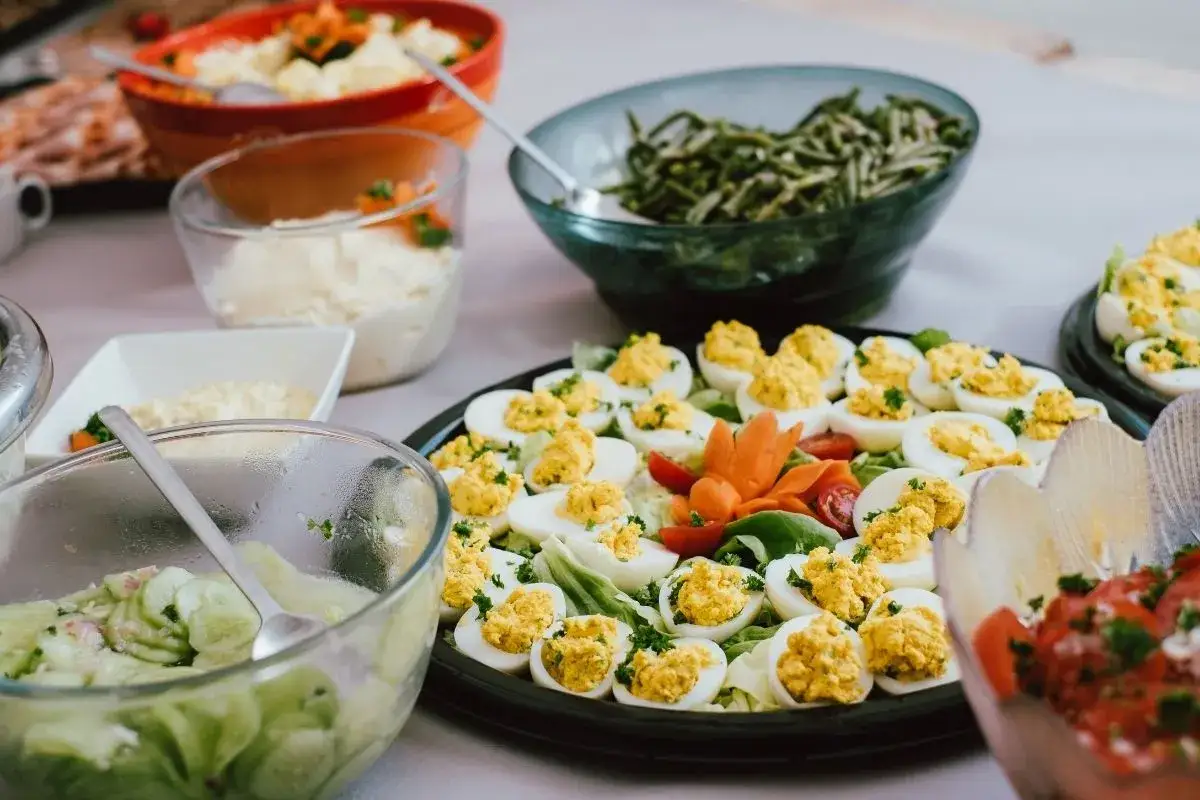 Oeufs mimosa recette grand-m&egrave;re : un plateau garni d'&oelig;ufs farcis, de salades et d'autres mets festifs, pr&ecirc;t &agrave; r&eacute;galer.
