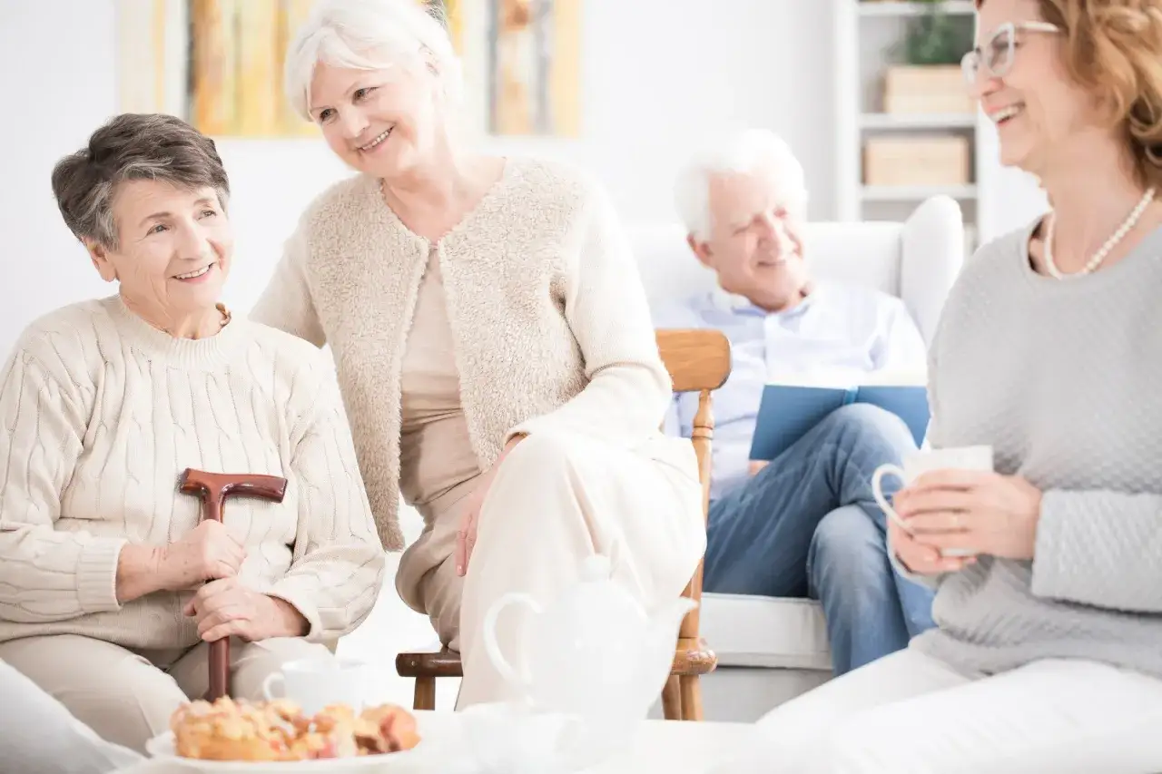 Uśmiechnięci seniorzy w centrum rehabilitacyjno opiekuńczym dla osób przewlekle chorych somatycznie.