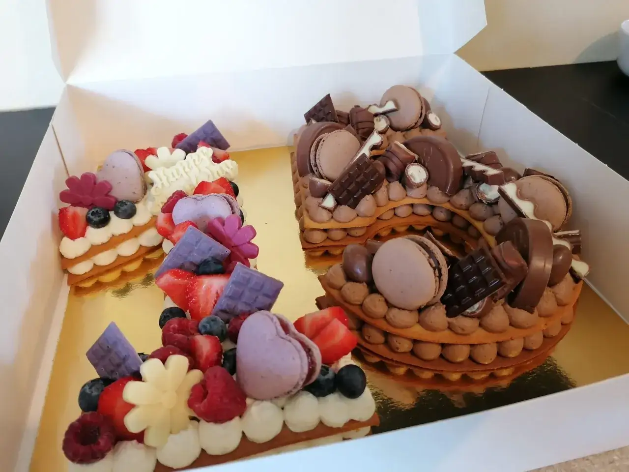 Deux number cakes, l'un aux fruits rouges et l'autre au chocolat, d&eacute;cor&eacute;s de macarons, chocolats et fruits. Un d&eacute;lice pour un anniversaire !