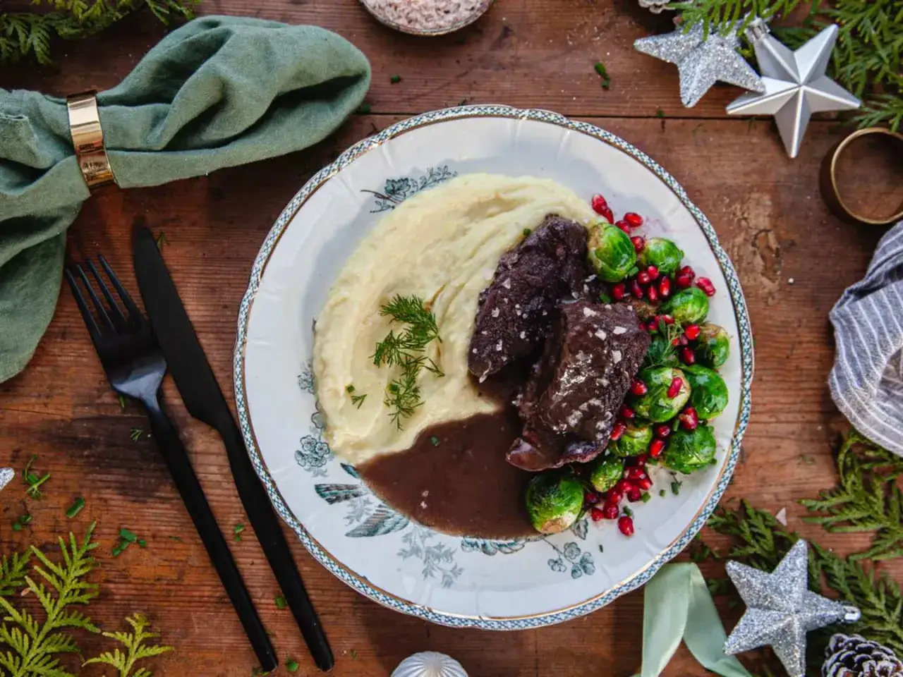 En festlig tallrik med oxkind, potatismos, brysselk&aring;l och granat&auml;pple. Ett perfekt oxkind recept f&ouml;r h&ouml;gtider.