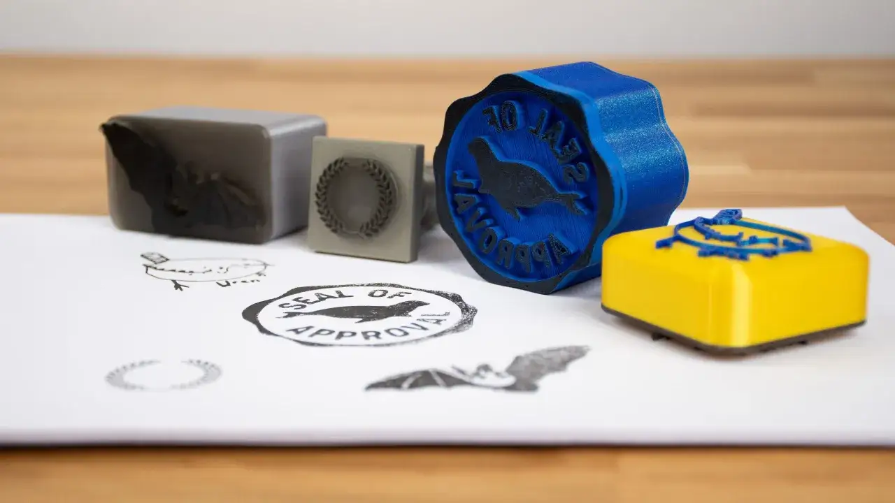 A collection of colorful 3d print stamps, including a blue one with a seal and 