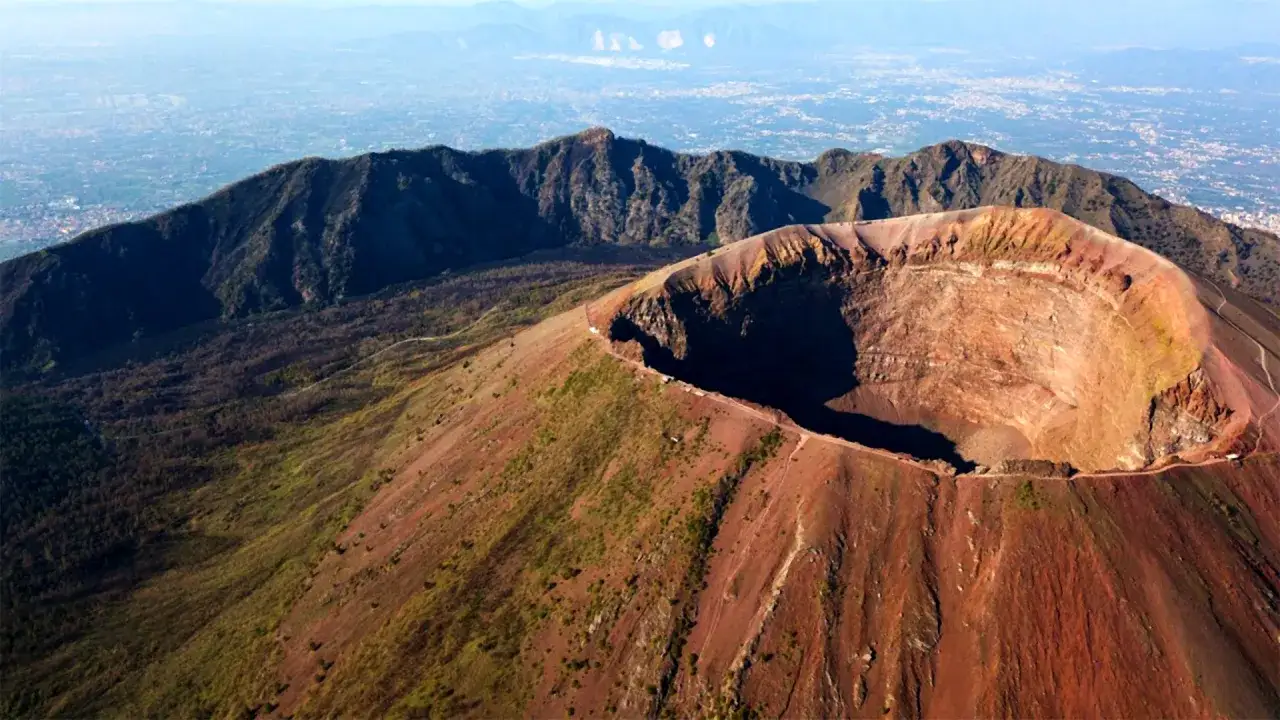 Il cratere del Vesuvio, con le sue pareti rossastre e la vista sulla pianura sottostante, testimonia la potenza della natura.
