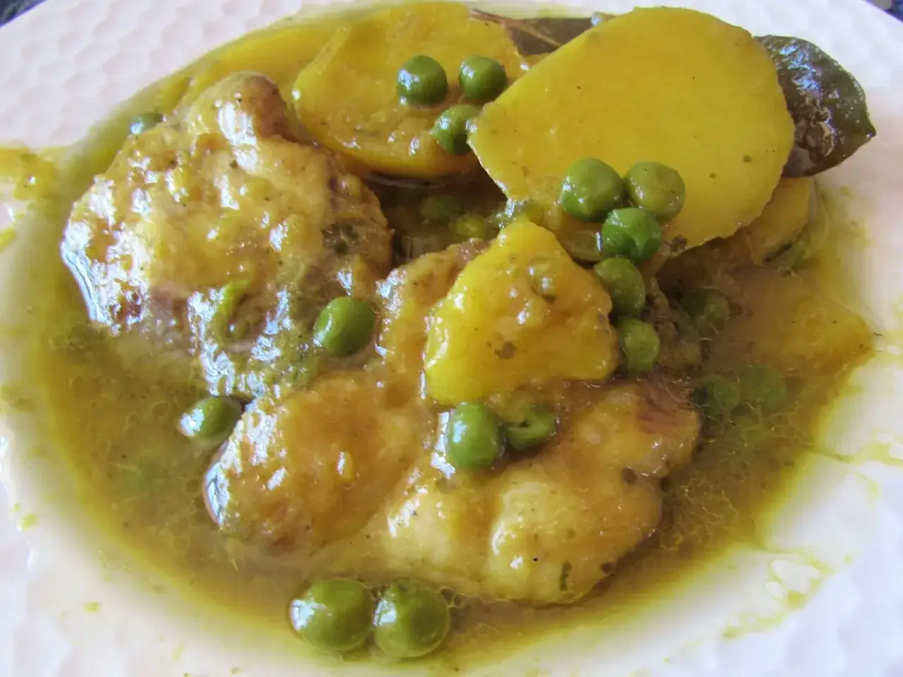 Sabroso cazon en amarillo con patatas y guisantes, bañado en una rica salsa.