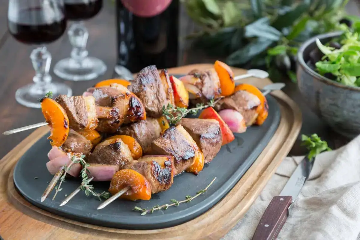 Brochettes de magret de canard marinées, juteuses et grillées, alternant avec des abricots et des oignons rouges. Un délice à savourer !