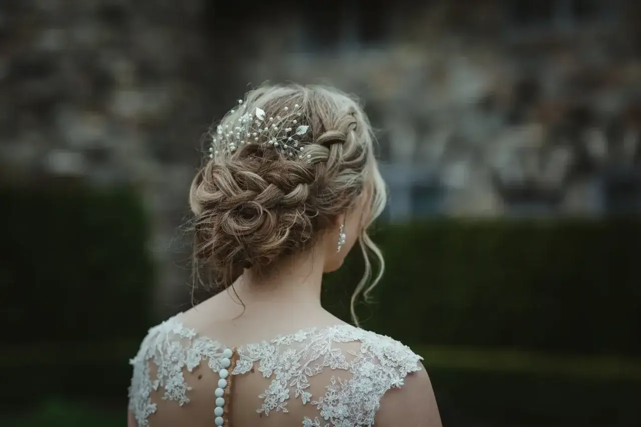 Eleganckie upięcie z warkoczy i loków, ozdobione biżuterią. Idealne pomysły na fryzurę ślubną.