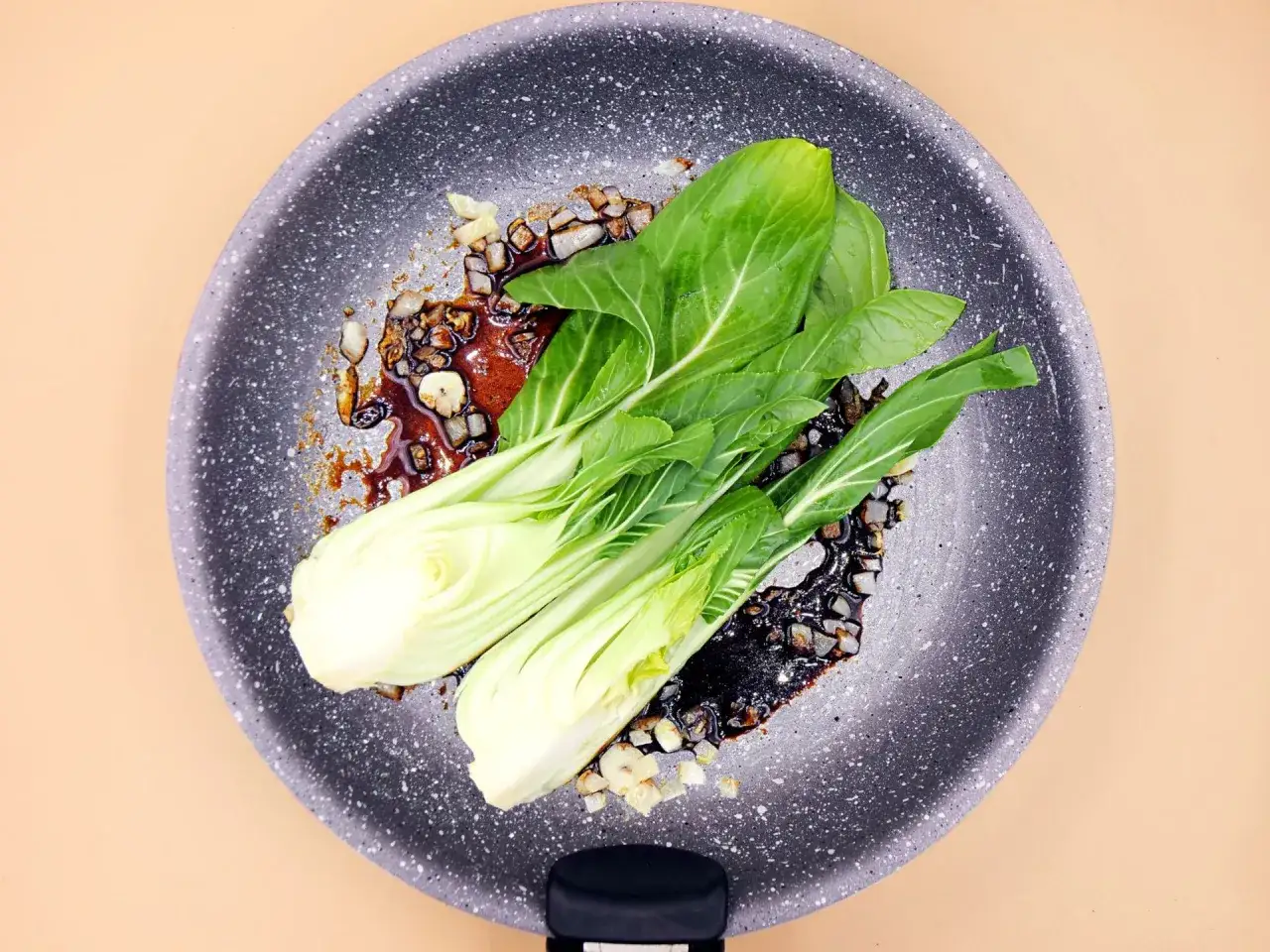 Świeży pak choi duszony na patelni z czosnkiem i sosem.