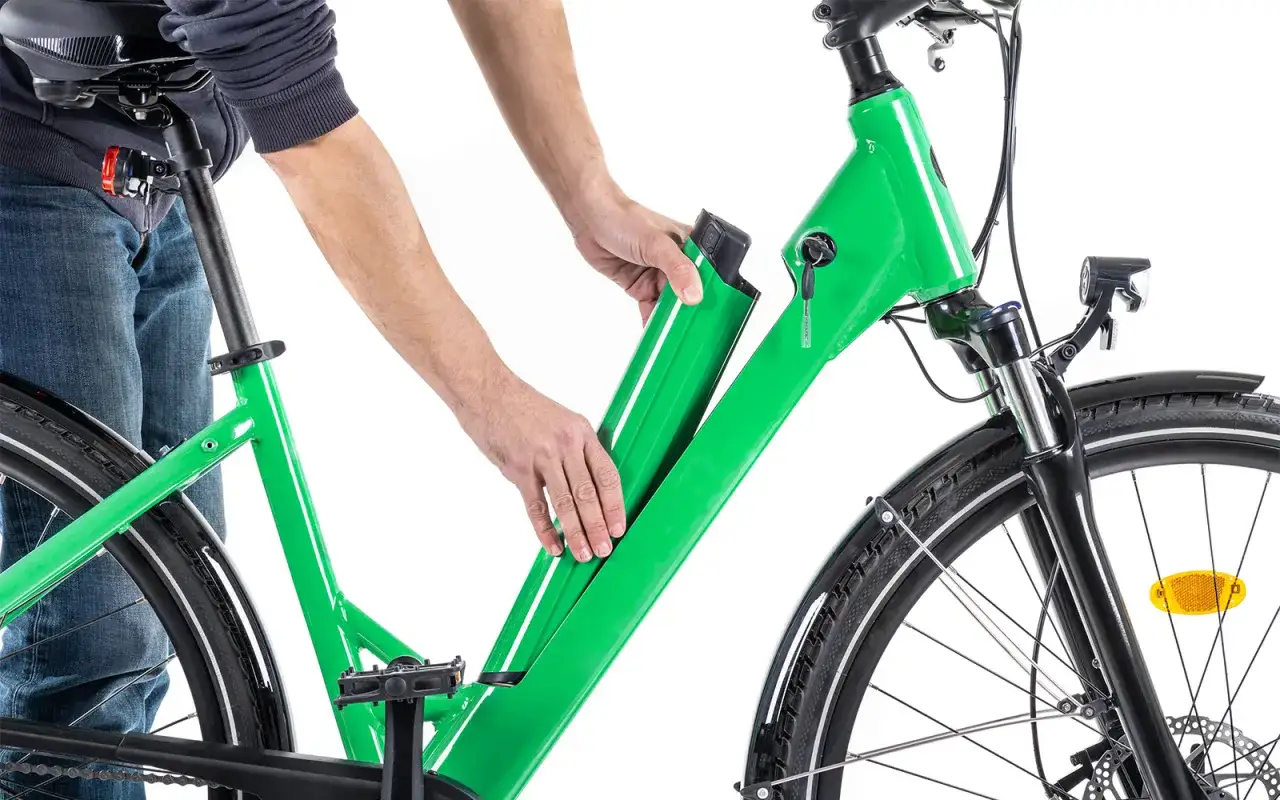Mann entfernt grünen e bike akku. Korrektes e bike akku entsorgen ist wichtig für die Umwelt.