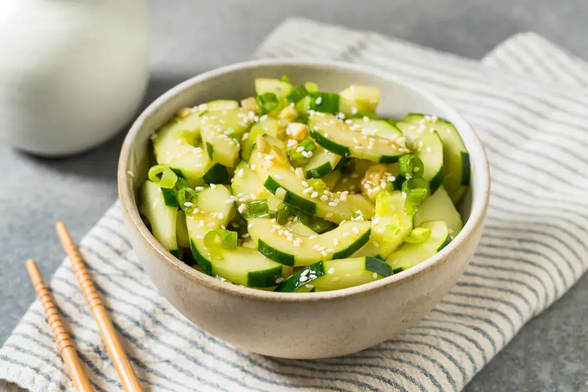 Una fresca insalata di cetrioli, condita con cipollotto e semi di sesamo, pronta per essere gustata.