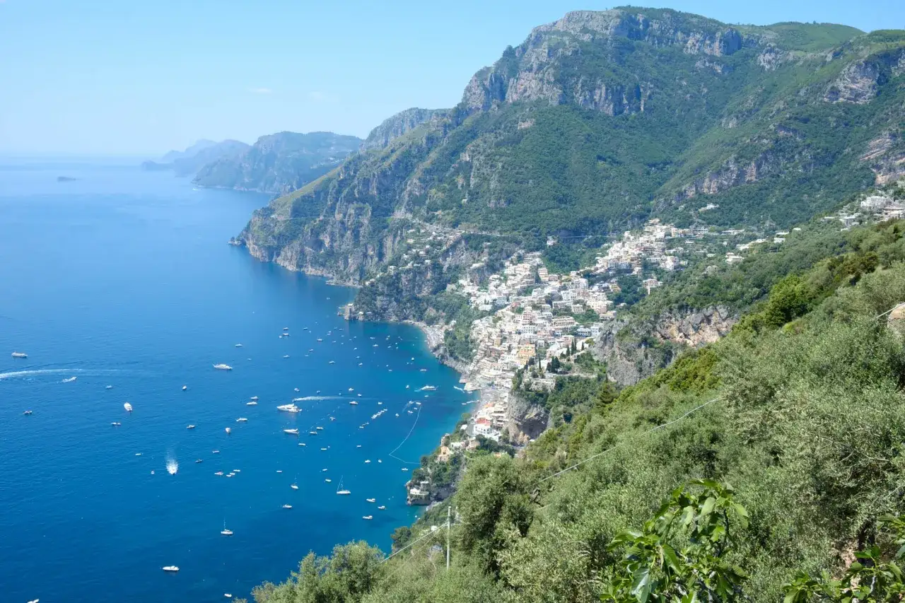 Vista mozzafiato del sentiero degli dei, dove si trova Positano, con il mare blu e tante barche.