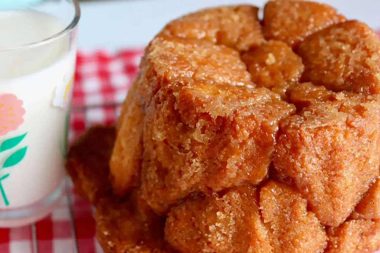 Słodki, karmelizowany monkey bread przepis. Idealny na śniadanie lub deser, podany z mlekiem w szklance z kwiatkami.