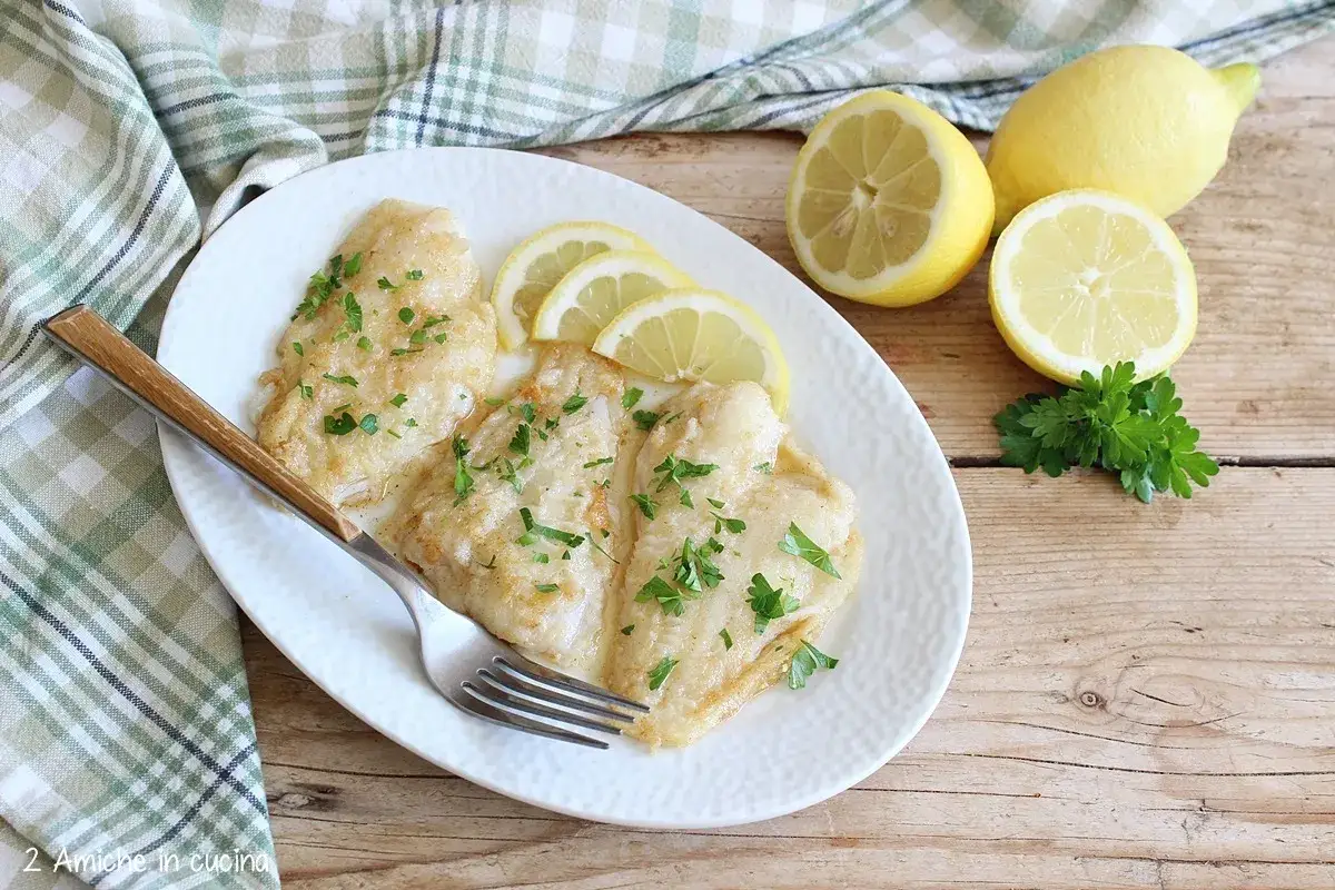 Tre filetti di sogliola alla mugnaia, dorati e profumati, guarniti con prezzemolo e spicchi di limone.