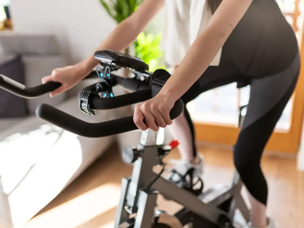 Person cycling indoors, experiencing the hiit cycling benefits of an intense workout.