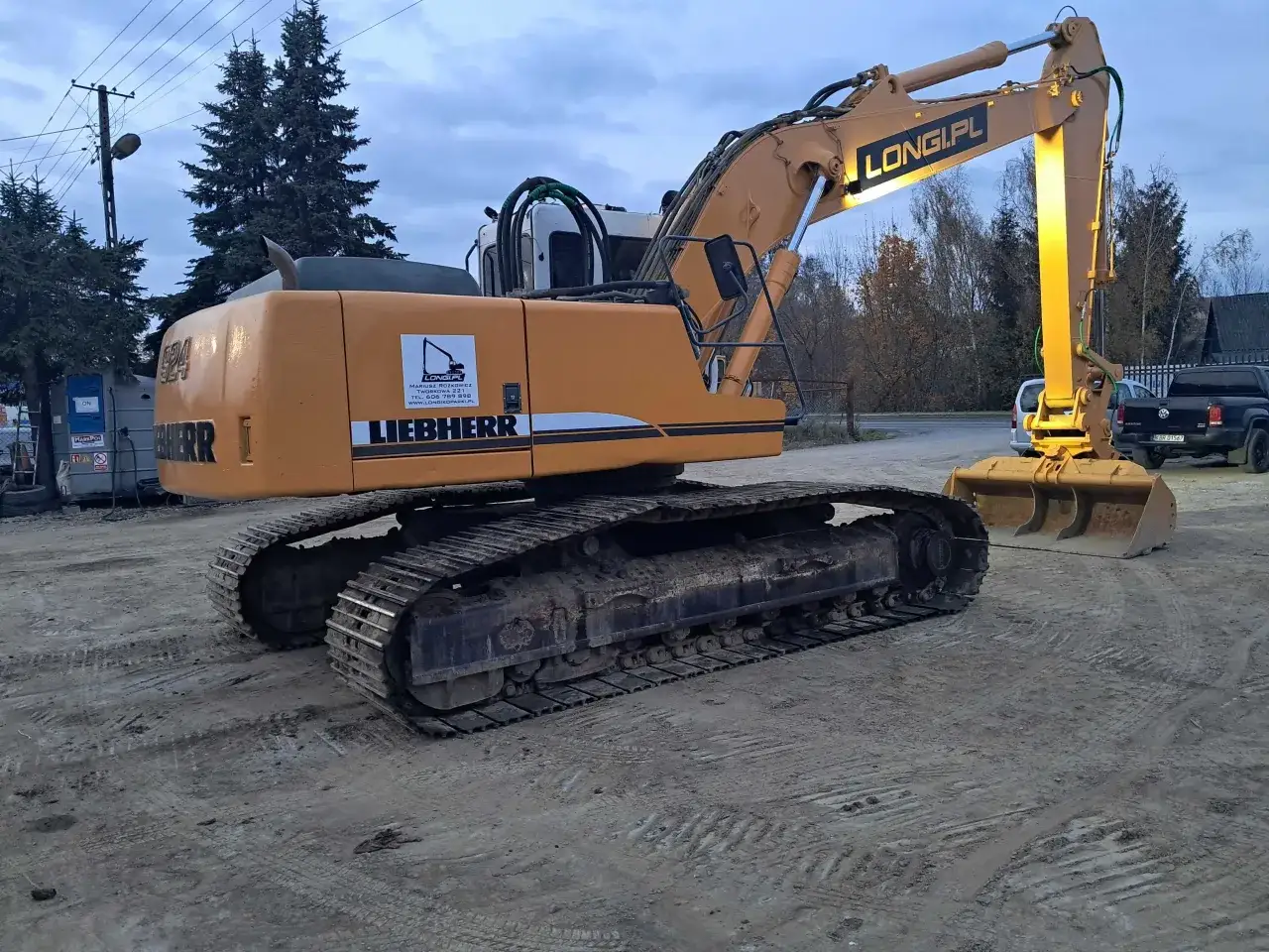 Pomarańczowa koparka gąsienicowa Liebherr gotowa do pracy. Dostępny wynajem koparki gąsienicowej na długoterminowe projekty budowlane.