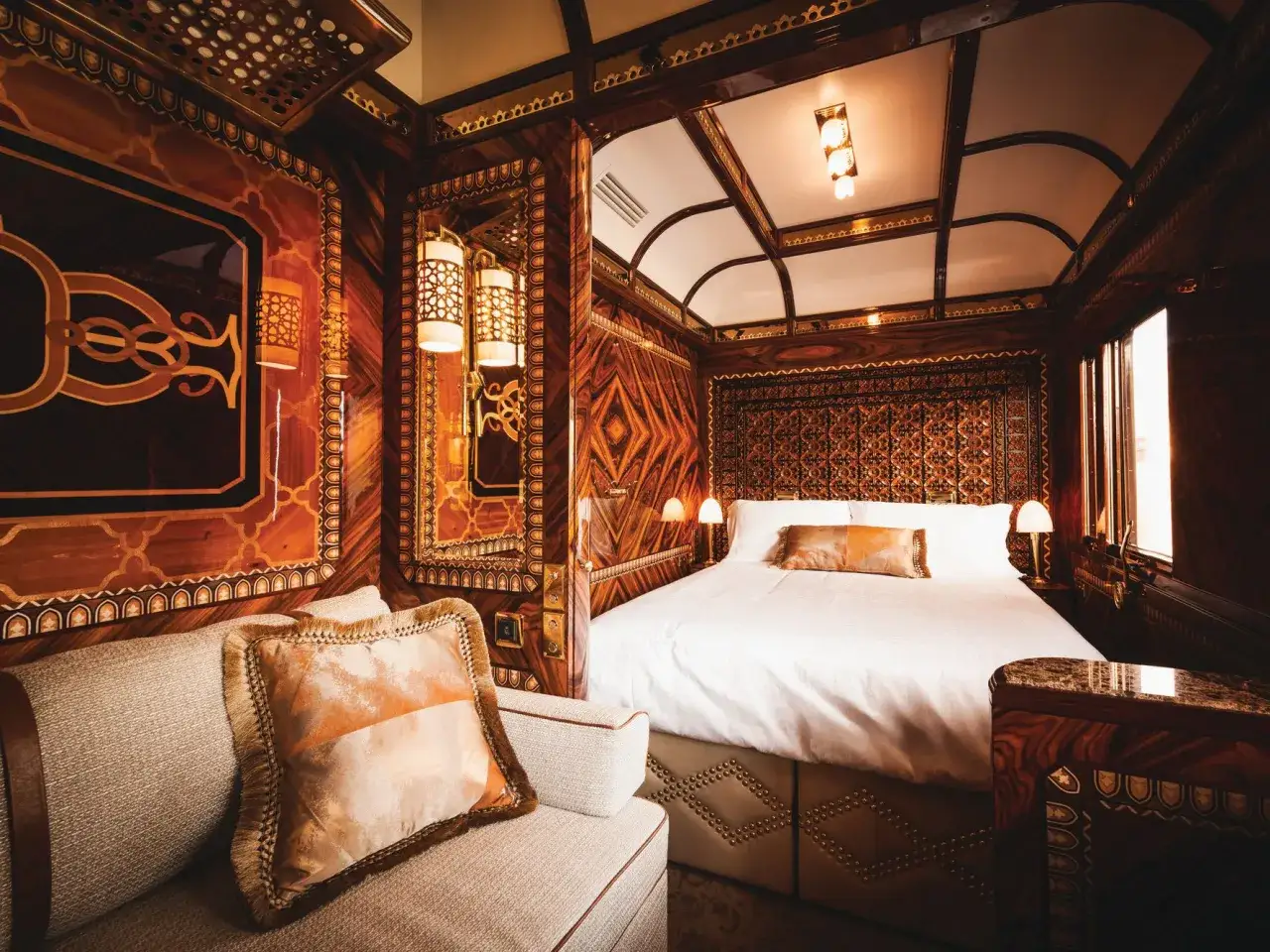 Luxuriöses Schlafabteil im teuersten Zug der Welt. Edles Holzdekor, ein bequemes Bett und ein Sofa laden zum Entspannen ein.