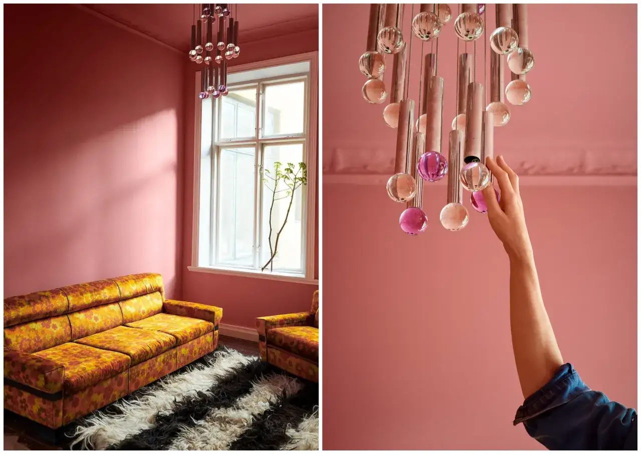 Salon w odcieniach różu z kanapą w kwiaty i designerską lampą. Różowe dodatki do salonu dodają mu uroku.