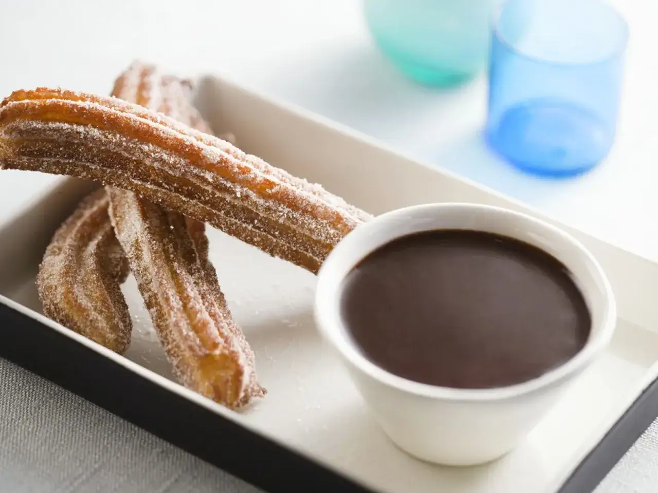 Zucker&uuml;berzogene Churros mit Schokoladensauce, ein k&ouml;stliches Churros Rezept zum Genie&szlig;en.