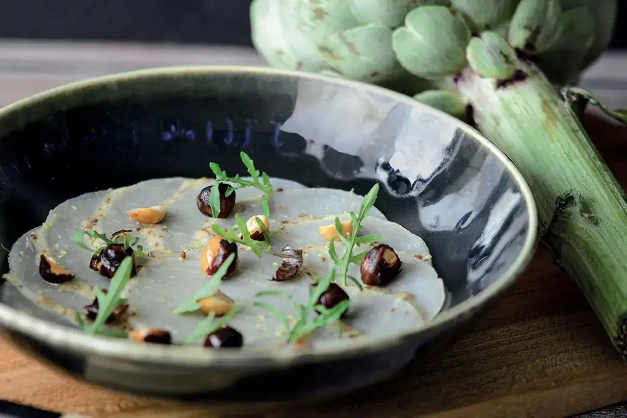 Carpaccio d'artichaut, une recette l&eacute;g&egrave;re et raffin&eacute;e, garnie de noisettes torr&eacute;fi&eacute;es et de roquette fra&icirc;che.