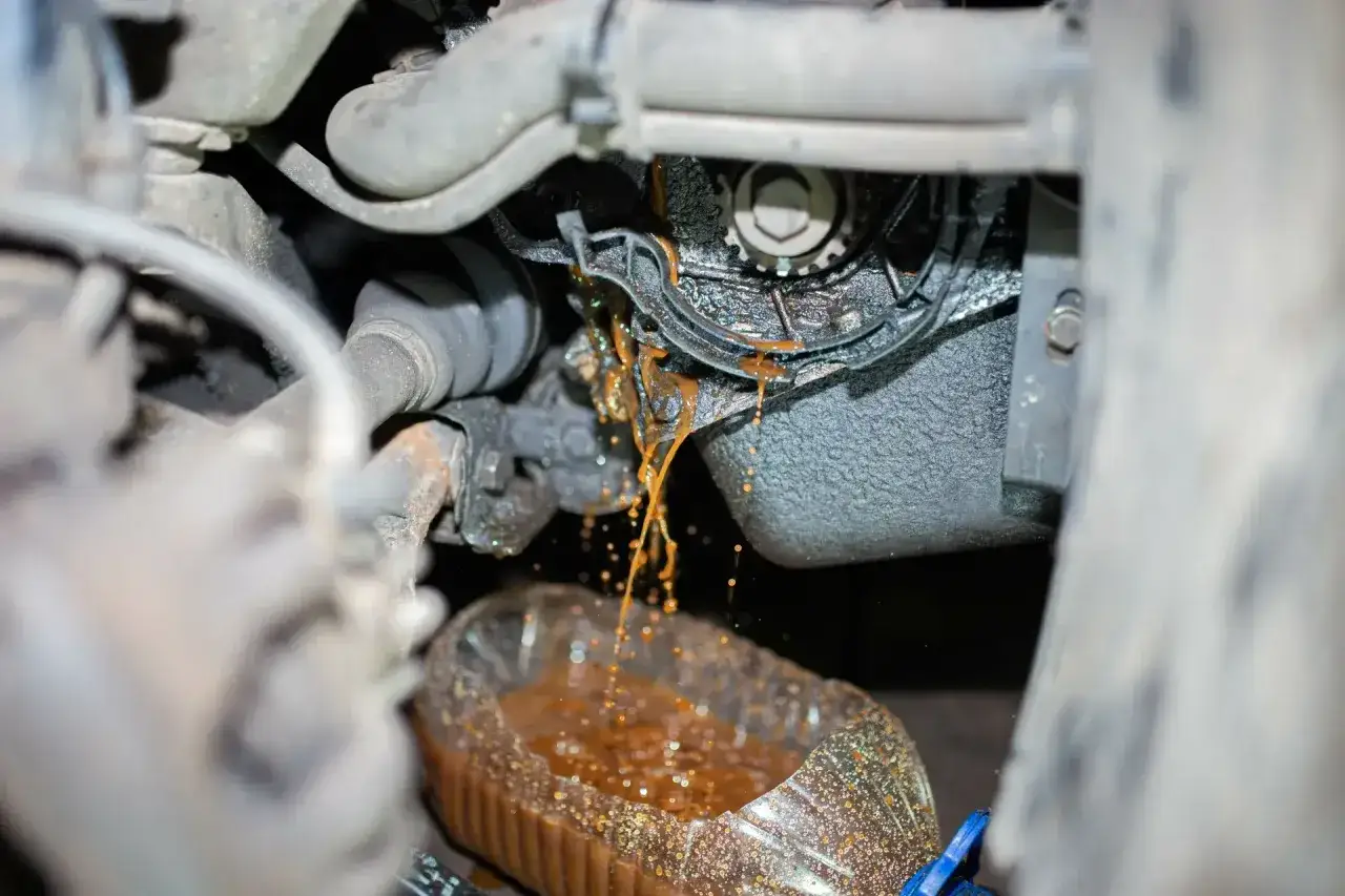 Flüssigkeit tropft aus der defekten wasserpumpe auto in einen Behälter.