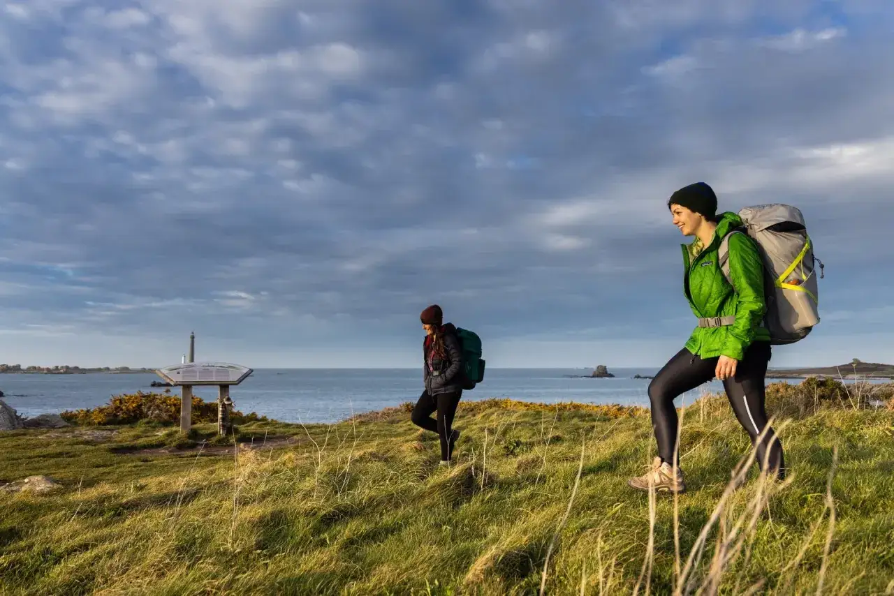 Deux randonneuses explorent la côte bretonne, profitant d'une belle journée pour leur randonnée les abers Bretagne. Le paysage est magnifique.
