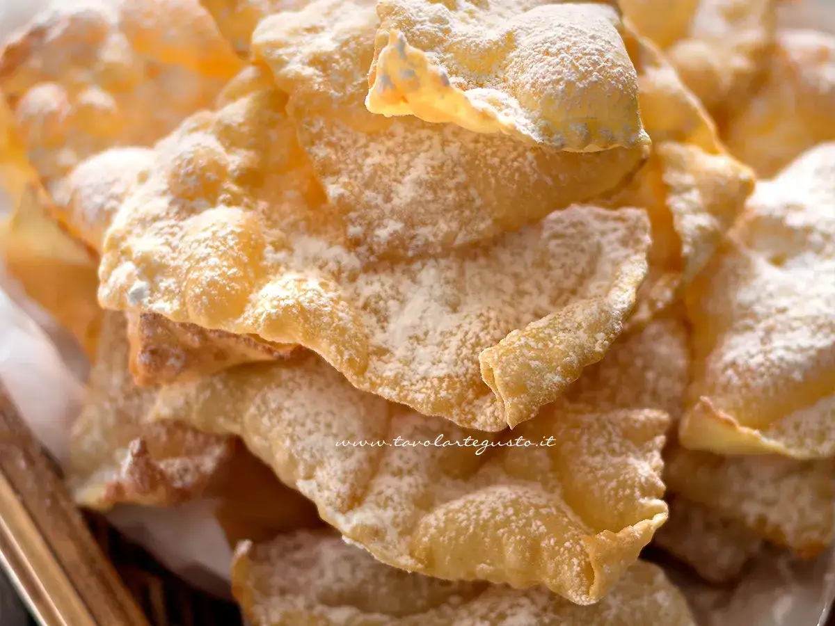 Un mucchio di chiacchiere morbide, dolci e croccanti, cosparse di zucchero a velo.