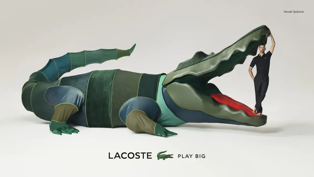 Novak Djokovic posa con un coccodrillo gigante, simbolo della lacoste storia. Il tennista è in piedi sulla lingua rossa dell'animale.