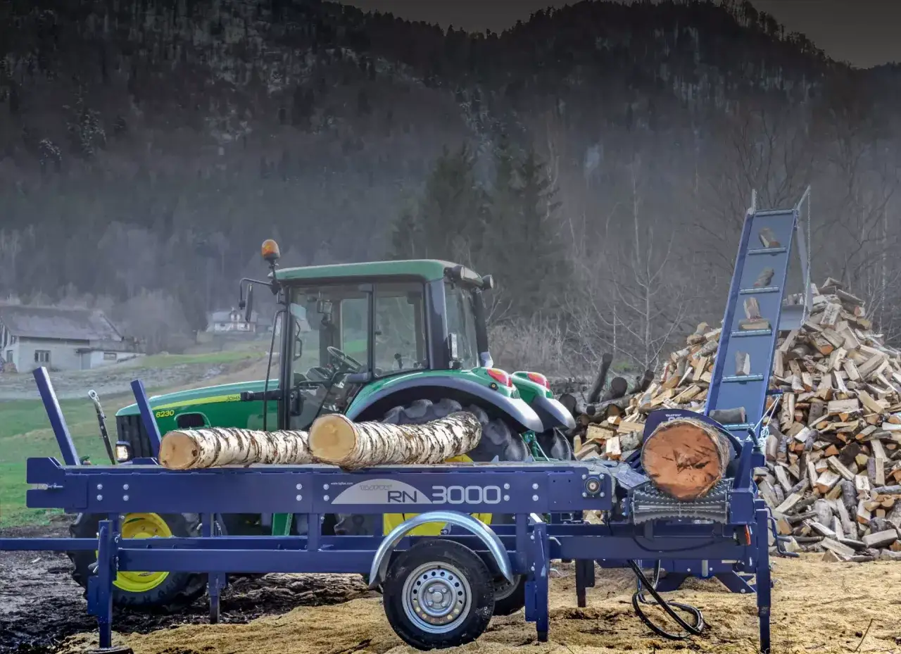 Ein Taifun Holzspalter RN 3000 mit einem Traktor im Hintergrund, bereit, Holz f&uuml;r den Winter zu spalten.