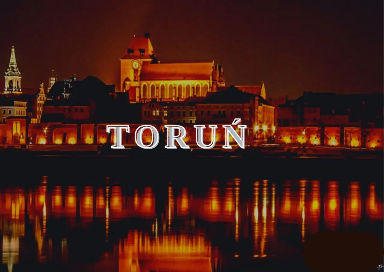 Nocny Toruń zachwyca. Widok na zabytkowe kamienice i katedrę nad Wisłą, z odbiciem świateł w wodzie. Odkryj toruń atrakcje!