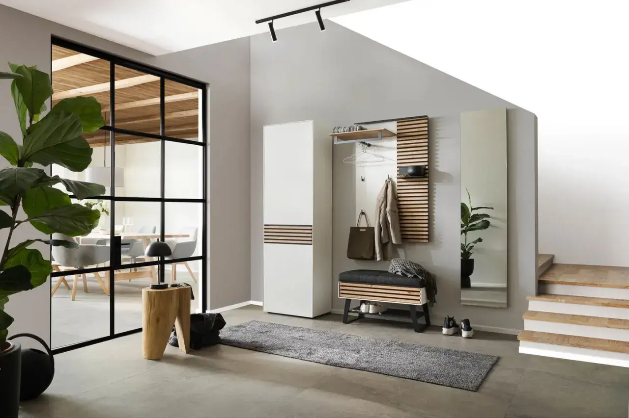 Modern und funktional: So lässt sich der eingangsbereich gestalten. Ein weißer Schrank, Garderobenpaneel mit Holzlamellen und eine Sitzbank schaffen Ordnung.