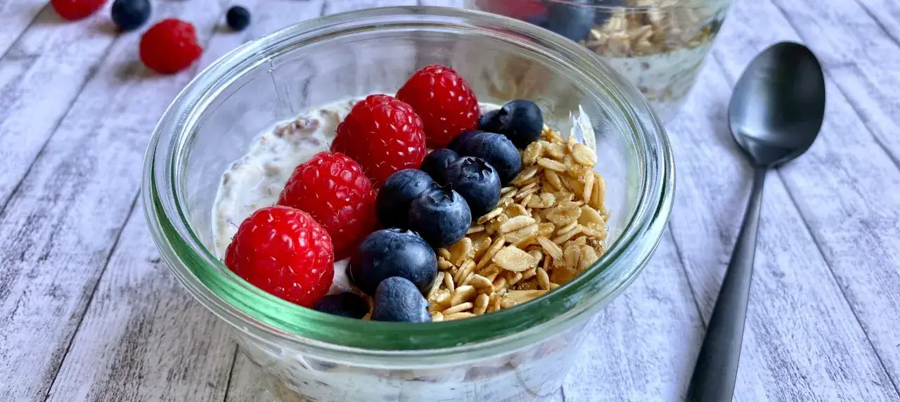 Fr&uuml;hst&uuml;cks-Bowl mit Quark, Beeren und Granola. Eine gesunde Mahlzeit, die zeigt, wieviel Quark am Tag gut f&uuml;r dich ist.