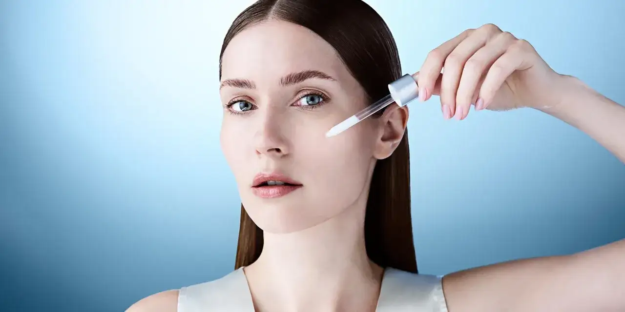 Donna applica un siero viso con hydroxypinacolone retinoate, per una pelle luminosa e giovane.