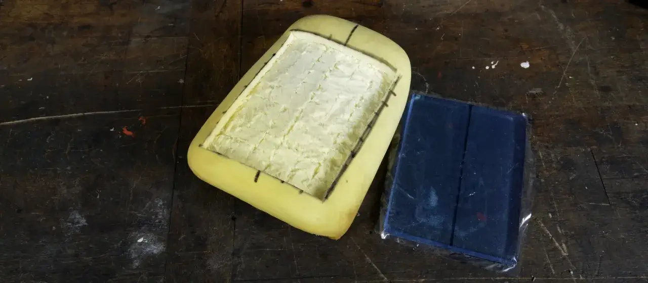 Schiuma per cuscino sella moto fai da te, con un pezzo blu avvolto in plastica.
