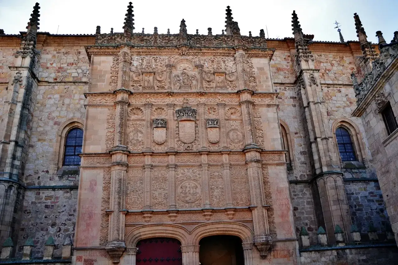 Façade ornée de l'université pontificale de Salamanque, avec ses blasons et sculptures complexes.