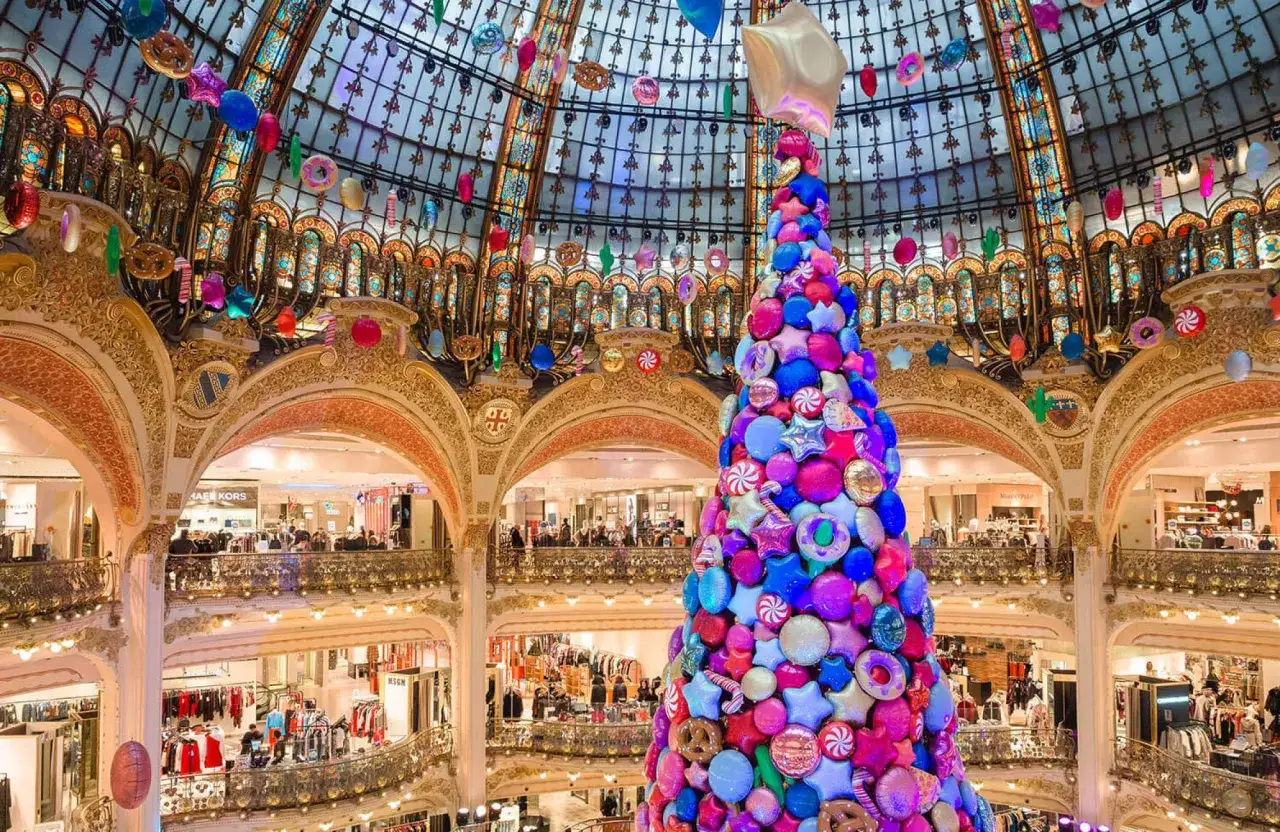 Arbre de Noël géant fait de bonbons et de ballons colorés, sous le dôme orné de vitraux. Une féerique deco noel paris.