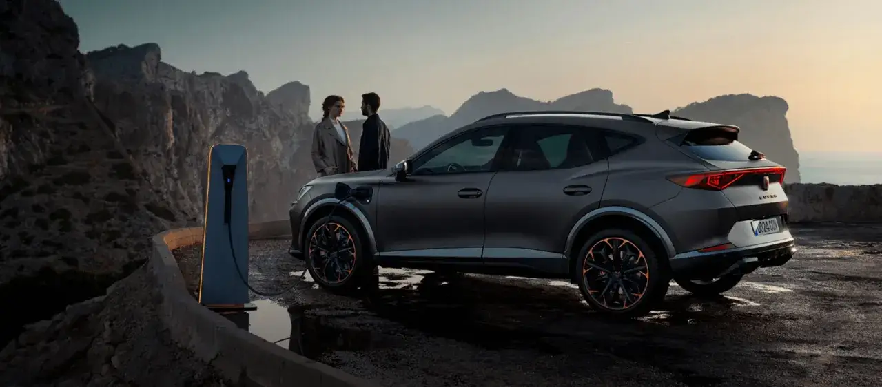 Para, co to za marka? Elegancki SUV Cupra ładuje się na tle malowniczych gór.
