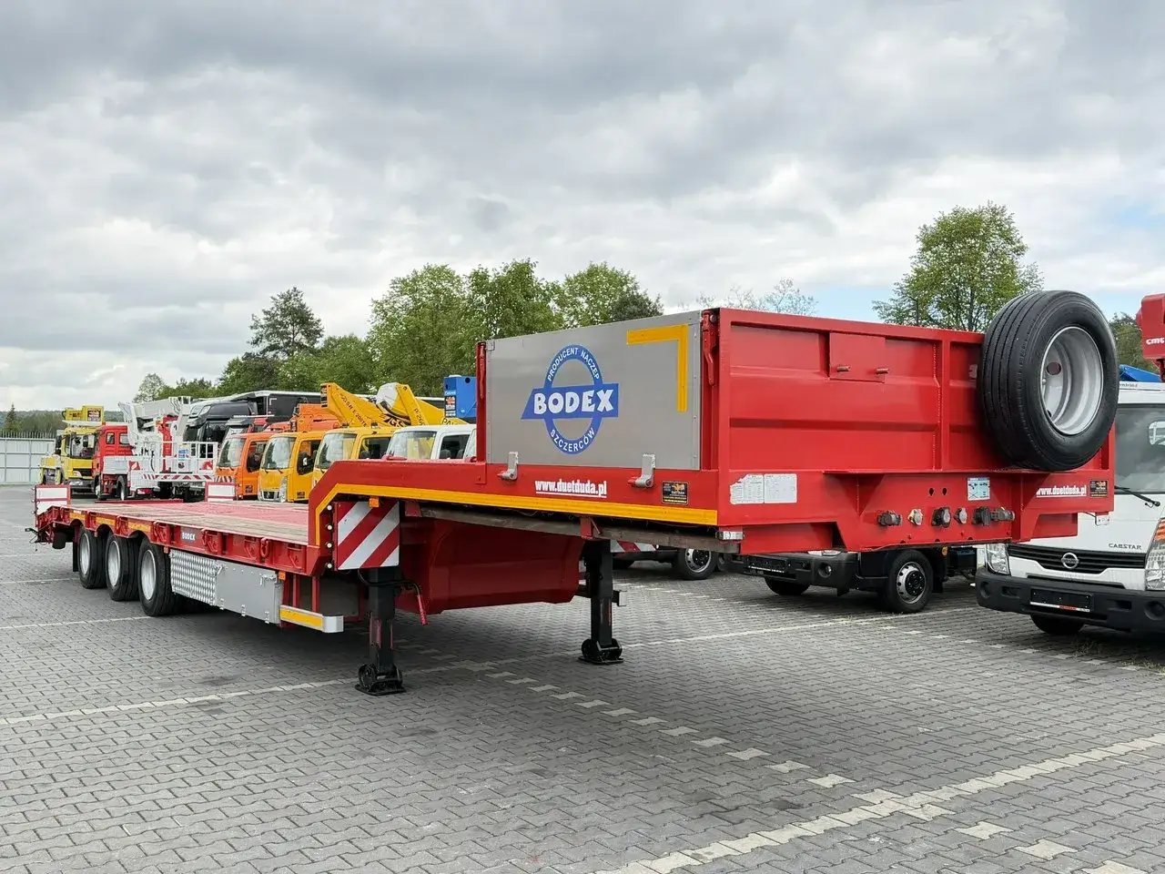 Czerwona naczepa niskopodłogowa Bodex, 3 osiowy samochód z dużą ładownością, gotowa do transportu ciężkiego sprzętu.